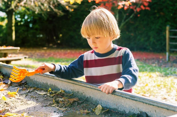 Menino brincando em sandbox enlameado — Fotografia de Stock