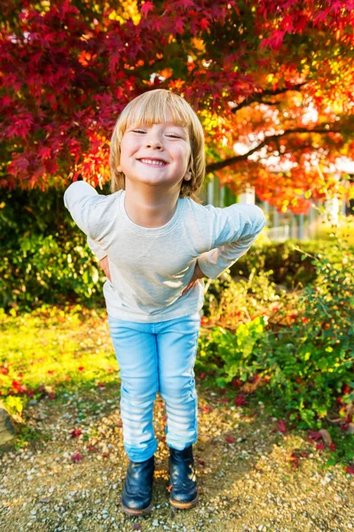 Retrato de outono ao ar livre de um menino bonito de 4 anos de idade em um dia ensolarado agradável, vestindo top bege, jeans jeans jeans azul claro e botas — Fotografia de Stock