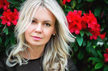 Arka plan üzerinde kırmızı çiçekli güzel sarışın kadın