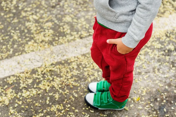 Little boy in red joggers and green shoes — Stock Photo, Image