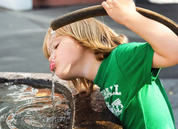 Menino bebendo de uma fonte de água — Fotografia de Stock