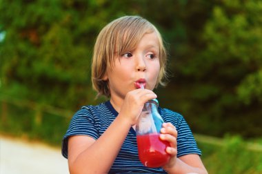 Sevimli küçük çocuk içme smoothie açık havada sallamak