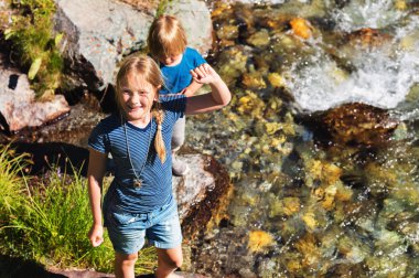 Güzel bir yaz gününde dağ nehri ile oynayan iki sevimli çocuk, üst görünümü