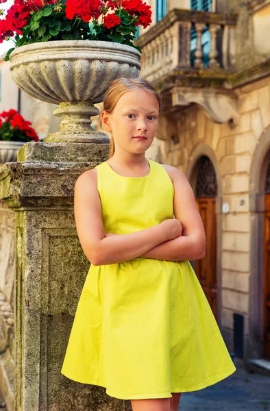 Toskana, İtalya eski sokakta 8-9 yaşında sevimli bir küçük kız Açık moda portresi. Yeşil elbise giyen preteen çocuk, kollar çapraz, dikey görüntü — Stok fotoğraf