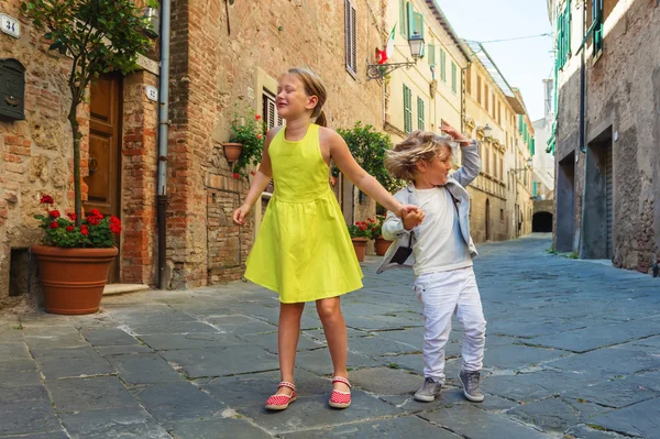 Очаровательные дети веселятся на открытом воздухе, танцуют на улицах старого итальянского города — стоковое фото