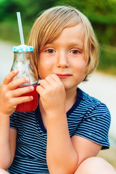 Bonito menino bebendo batido shake ao ar livre — Fotografia de Stock