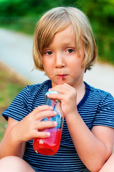 Bonito menino bebendo batido shake ao ar livre — Fotografia de Stock