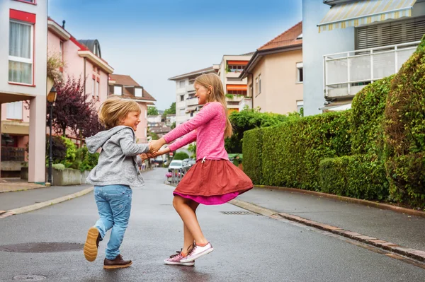 Nuttede børn har det sjovt udendørs, danser på gaden - Stock-foto