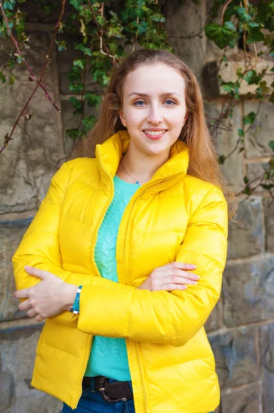 Açık parlak sarı ceket, dikey görüntü giyen genç bir kadın portresi — Stok fotoğraf