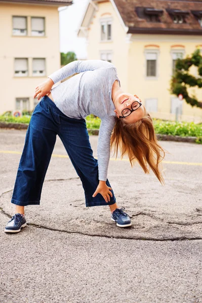 Retrato divertido al aire libre de una linda niña de 8-9 años de edad, con ropa azul y gafas —  Fotos de Stock