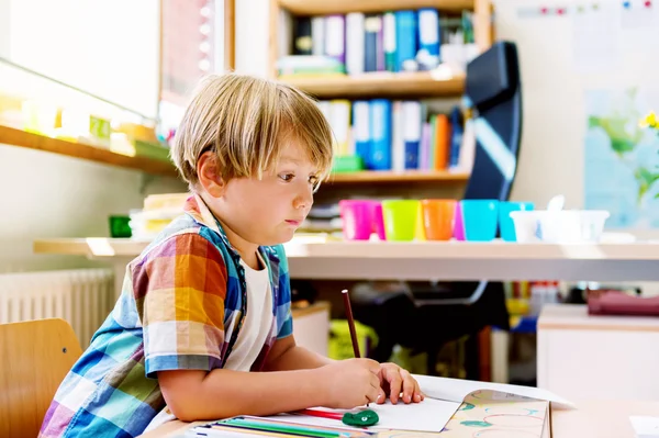 Indoor portrait of a cute little boy in a classroom — Stock Photo, Image