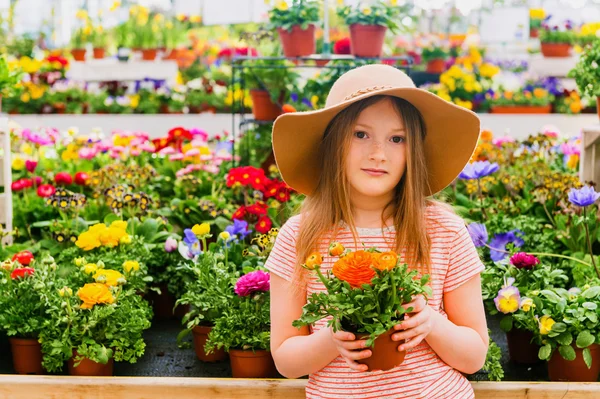 Schattig meisje kiezen bloemen in tuincentrum — Stockfoto