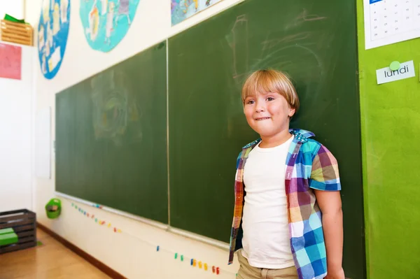 Indoor portrait of a cute little boy in a classroom — Stock Photo, Image