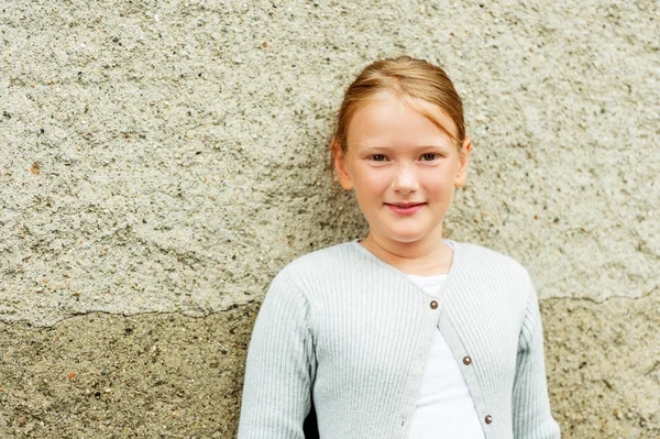 Retrato de cerca de una linda niña de 8-9 años, con chaqueta de punto gris — Foto de Stock