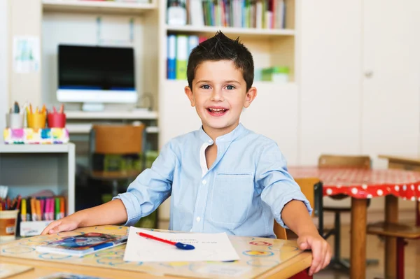 Indoor portrait of a cute little boy in a classroom — Stock Photo, Image