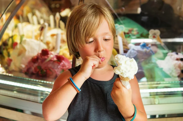 Bonito menino de criança comendo sorvete italiano na loja — Fotografia de Stock