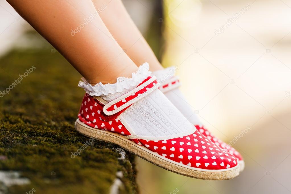 Close up of red polka dot shoes on child's feet