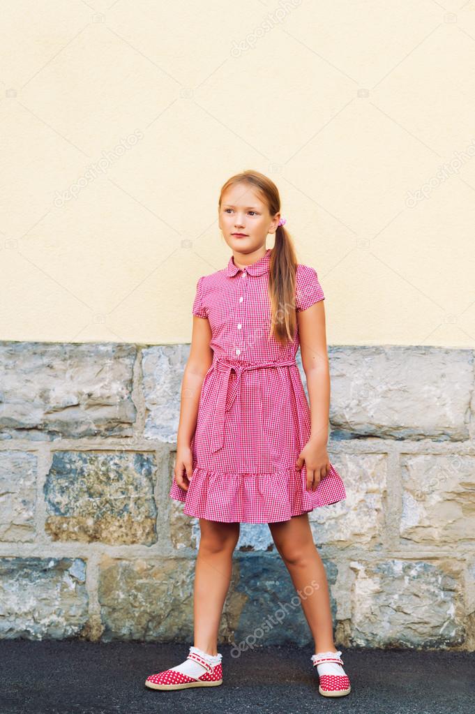 Outdoor portrait of cute little 8 year old girl, wearing red mary jane  dress Stock Photo by ©annanahabed 124094044
