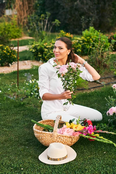 Zdrowa Szczęśliwa Kobieta Pracująca Ogrodzie Kwiatowym Siedząca Trawie Krojąca Kwiaty — Zdjęcie stockowe