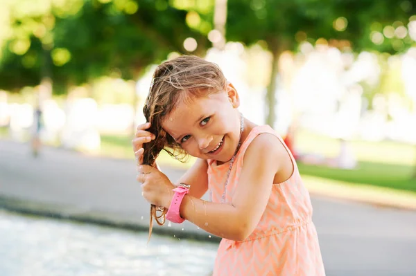 面白い女の子は噴水で髪を濡らします 暑い夏の日 子供は外で遊んで — ストック写真