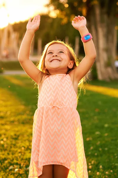 4岁小女孩在暑期公园玩耍的户外肖像 举起胳膊 戴着漂亮的手表 明亮的绿色草坪上阳光灿烂 — 图库照片
