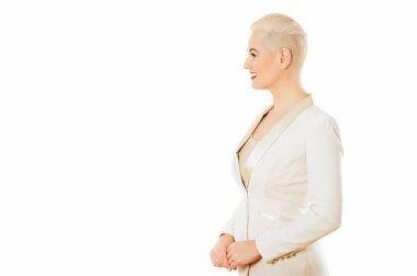 Beyaz ceketli güzel bir kadının profil portresi, stüdyoda beyaz arka planda poz, kısa saç kesimi.