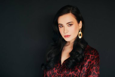 Asyalı güzel bir kadının moda portresi, profesyonel makyaj ve saç stili, kırmızı leopar desenli elbise giyiyor.