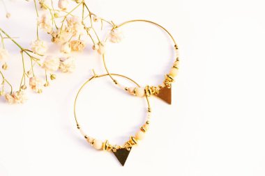 Beyaz arkaplanda el yapımı modern küpelerin resmini kapat