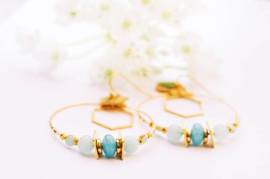 Beyaz arkaplanda el yapımı modern küpelerin resmini kapat