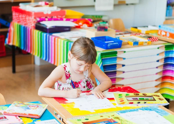 Niedliches kleines Mädchen, das in einem Klassenzimmer arbeitet — Stockfoto