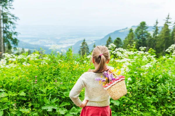 Portrait of a cute little girl with basket with flowers — Stock Photo, Image