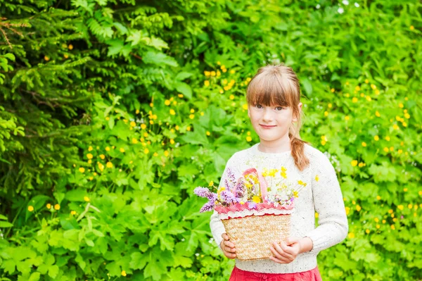 Portrait of a cute little girl with basket with flowers — Stock Photo, Image