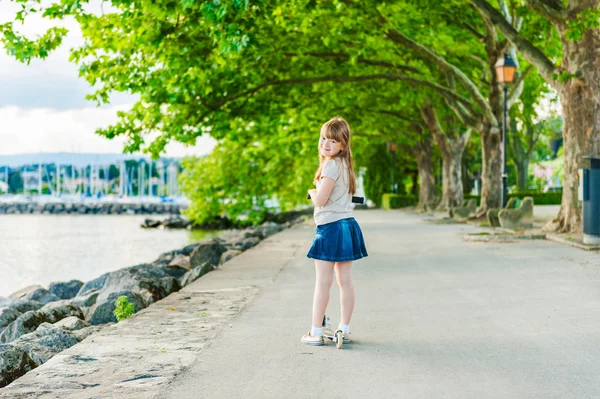 Ritratto all'aperto di una bambina carina su uno scooter — Foto Stock