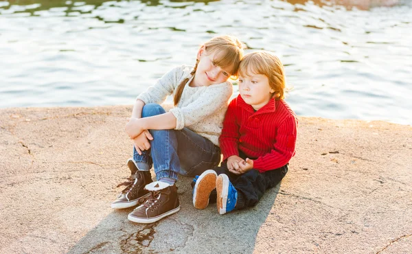 Retrato al atardecer de niños adorables descansando junto al lago — Foto de Stock