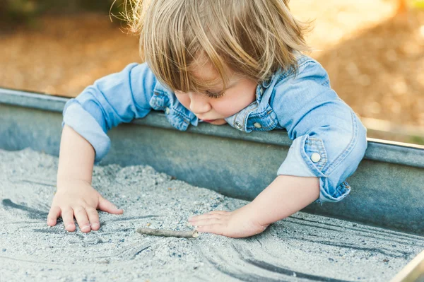 Мальчик Тоттлер играет в песочнице — стоковое фото