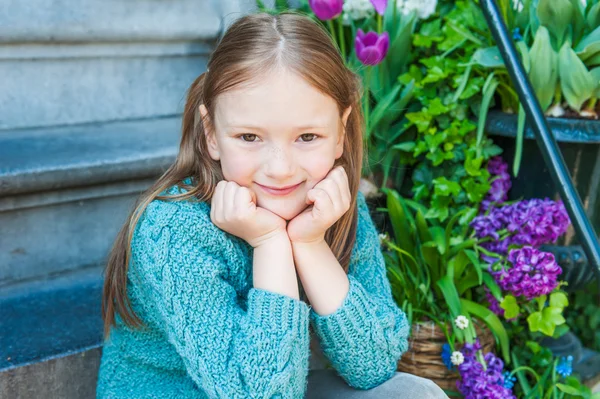 Outdoor portrait of a cute little girl sitting on steps in a city on a nice spring day — Stock Photo, Image