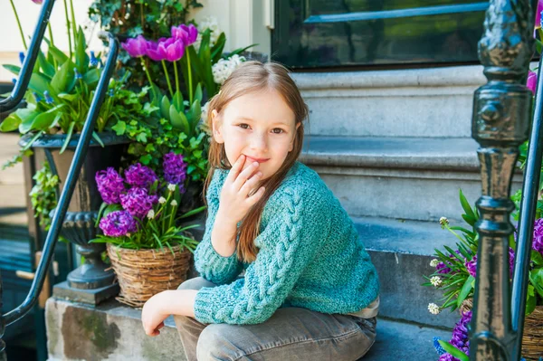 Outdoor Portret van een schattig klein meisje, zittend op stappen in een stad op een mooie lentedag — Stockfoto