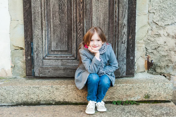 Außenporträt eines süßen kleinen Mädchens im grauen Mantel — Stockfoto