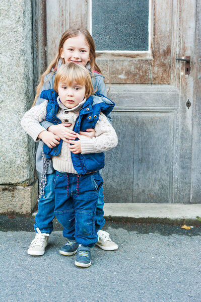 Outdoor portrait of a little girl and her brother