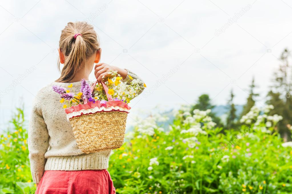 Portrait of a cute little girl with basket with flowers
