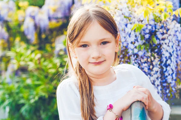 Portrait extérieur d'une jolie petite fille contre un beau lilas par une belle journée de printemps — Photo