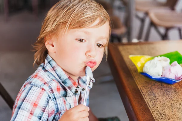 Schattig peuter jongen eten van ijs in een café — Stockfoto