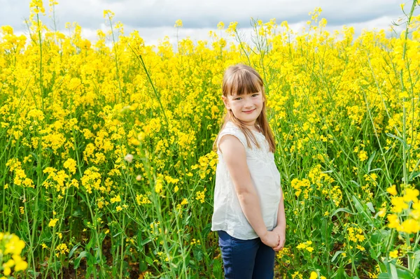 Ritratto all'aperto di una graziosa bambina che gioca con i fiori in campagna — Foto Stock
