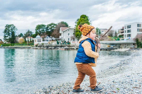 Bonito menino criança jogando ao lado do lago — Fotografia de Stock