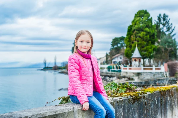 Outdoor portrait of a cute little girl in a bright pink jacket — Stock Photo, Image