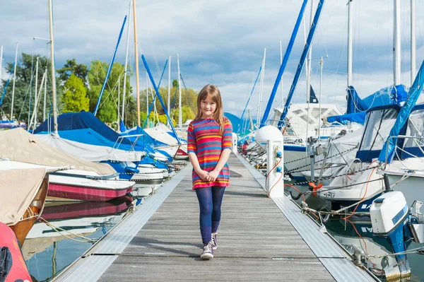 Außenporträt eines niedlichen kleinen Mädchens in einem Hafen, an einem schönen sonnigen Frühlingstag — Stockfoto