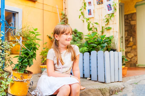 Söt liten flicka vilar i en liten vacker trädgård — Stockfoto