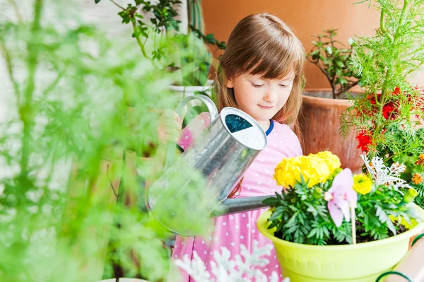 Adorable little girl watering flowers — Stock Photo, Image