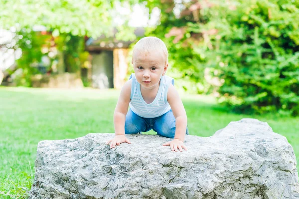 公園で大きな石で主張するかわいい幼児男の子の屋外のポートレート — ストック写真