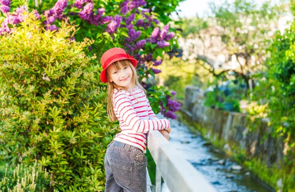 Retrato ao ar livre de uma menina bonita em um chapéu vermelho, em um dia ensolarado agradável — Fotografia de Stock